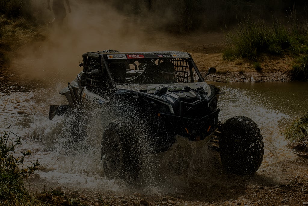 Side by side UTV splashing through muddy water